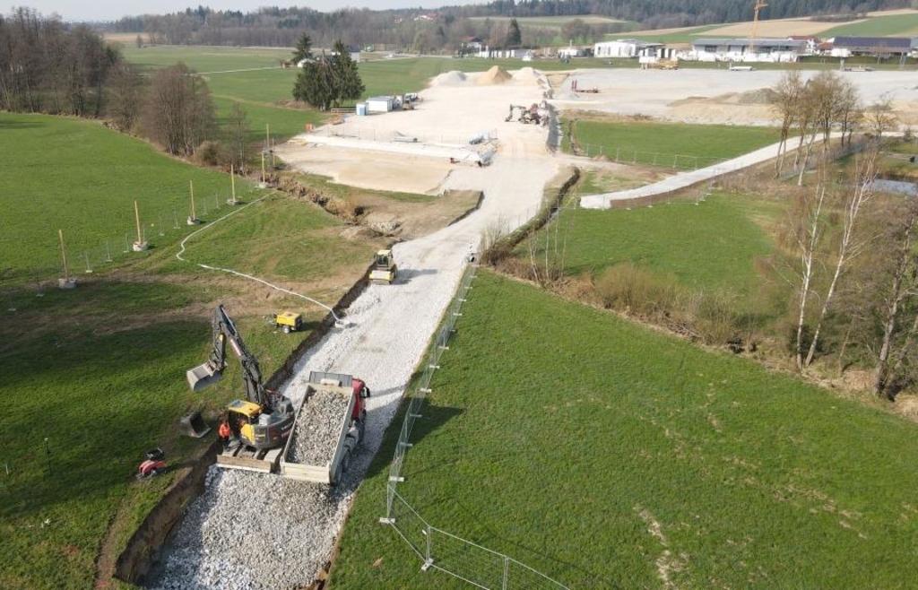 Zu den vorbereitenden Arbeiten gehört der Bau einer Baustraße (im Vordergrund). Über diese kann auch das 120 Tonnen schwere Großbohrpfahlgerät bis zur Ohe transportiert werden. Die Baustraße dient später als Betriebsstraße unter der Brücke, die Zufahrt ist rechts im Bild bereits zu erkennen. Am Ende der Schotterschicht in der Bildmitte entsteht ein Widerlager der zukünftigen Talbrücke. - Foto: Staatliches Bauamt Passau / Süß Zu den vorbereitenden Arbeiten gehört der Bau einer Baustraße (im Vordergrund). Über diese kann auch das 120 Tonnen schwere Großbohrpfahlgerät bis zur Ohe transportiert werden. Die Baustraße dient später als Betriebsstraße unter der Brücke, die Zufahrt ist rechts im Bild bereits zu erkennen. Am Ende der Schotterschicht in der Bildmitte entsteht ein Widerlager der zukünftigen Talbrücke. - Foto: Staatliches Bauamt Passau / Süß