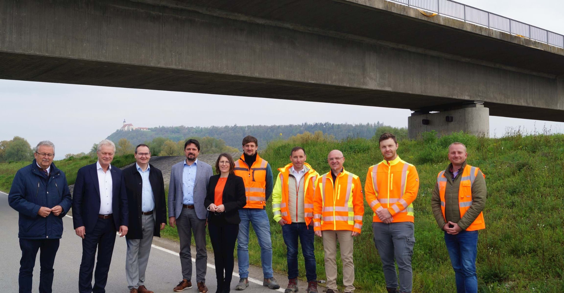 Landrat Josef Laumer, MdB Alois Rainer, Leitender Baudirektor Manfred Dreier, Aiterhofens Bürgermeister Adalbert Hösl, Bogens Bürgermeisterin Andrea Probst, Fabian Schrädobler (Ingenieurbüro Fritsche), Oberbauleiter Michael Lippl (Fa. Geiger), Tiefbauamtsleiter Markus Fischer, Thomas Zankl (Tiefbauverwaltung) und Bauleiter Adrian Kieres (Fa. Geiger) stehen unterhalb der Brücke, an deren Seitenrändern nun in den nächsten Monaten die Brückenkappe um einen Geh- und Radweg verbreitert wird. Im Hintergrund der Bogenberg. Landrat Josef Laumer, MdB Alois Rainer, Leitender Baudirektor Manfred Dreier, Aiterhofens Bürgermeister Adalbert Hösl, Bogens Bürgermeisterin Andrea Probst, Fabian Schrädobler (Ingenieurbüro Fritsche), Oberbauleiter Michael Lippl (Fa. Geiger), Tiefbauamtsleiter Markus Fischer, Thomas Zankl (Tiefbauverwaltung) und Bauleiter Adrian Kieres (Fa. Geiger) stehen unterhalb der Brücke, an deren Seitenrändern nun in den nächsten Monaten die Brückenkappe um einen Geh- und Radweg verbreitert wird. Im Hintergrund der Bogenberg.