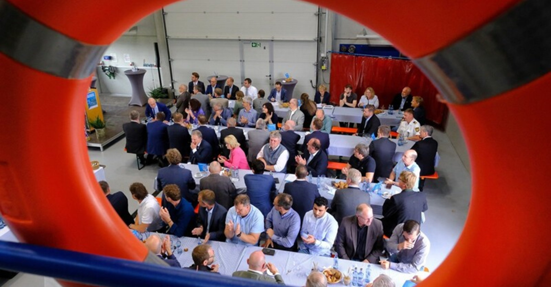 Durch den Rettungsring: Blick auf die Festversammlung in der Hafenmeisterei. -Foto: Ulli Scharrer Durch den Rettungsring: Blick auf die Festversammlung in der Hafenmeisterei. -Foto: Ulli Scharrer